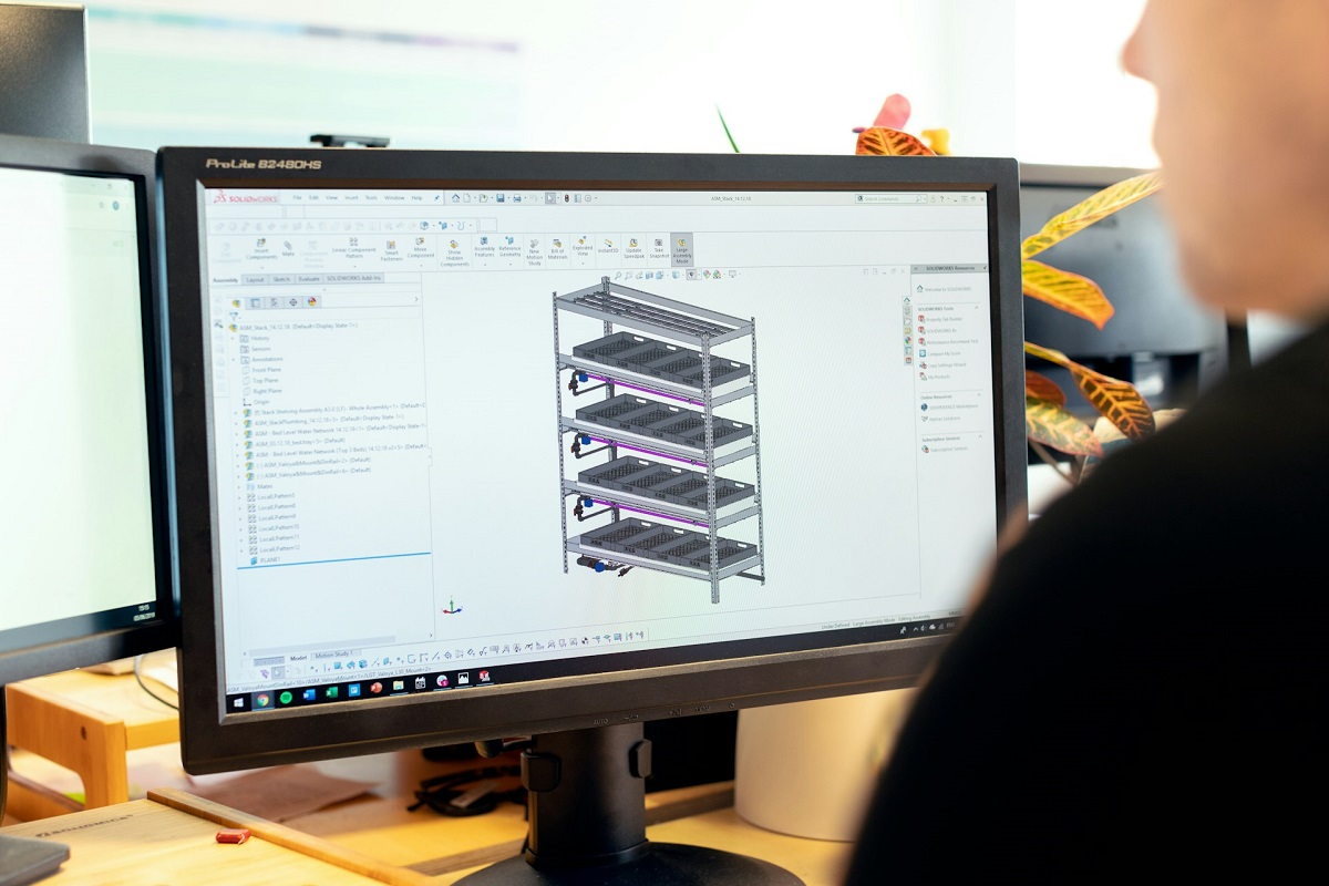 Ingénieur de bureau d'études modélisant une structure métallique en 3D sur un écran d'ordinateur.