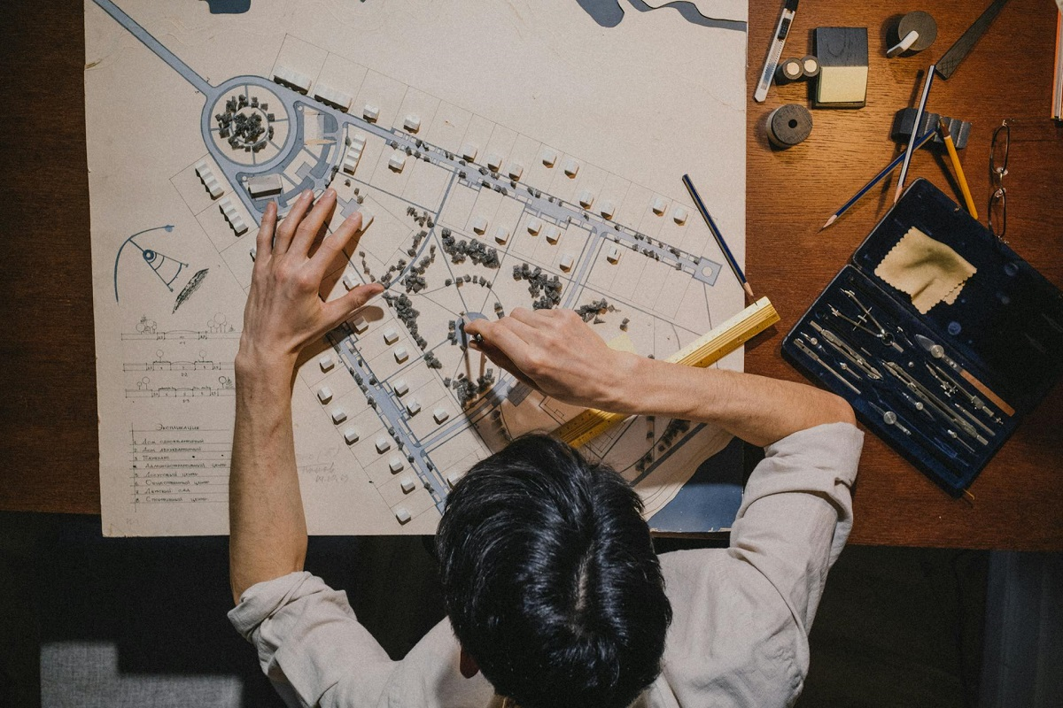 Ingénieur travaillant sur un plan d'aménagement et une maquette pour développer ses compétences en génie civil