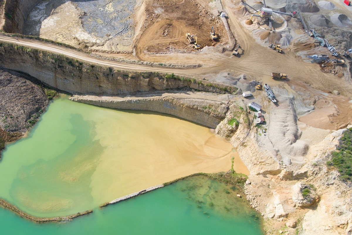 Vue aérienne d'une carrière avec bassins de décantation, illustrant la conformité aux normes en génie civil environnement.
