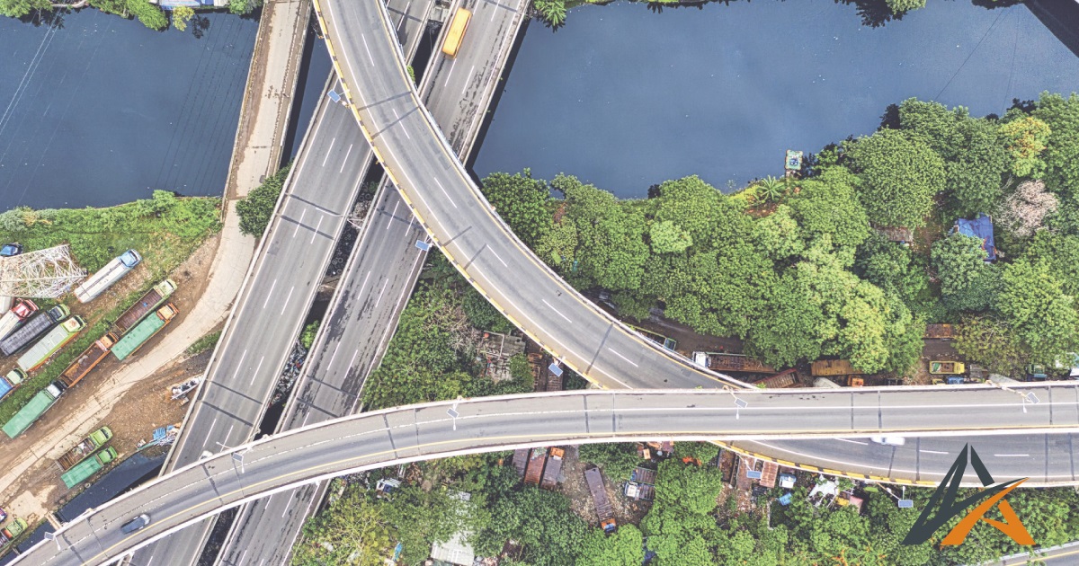 Vue aérienne d'infrastructures routières traversant un espace vert, illustrant les défis du génie civil environnement.